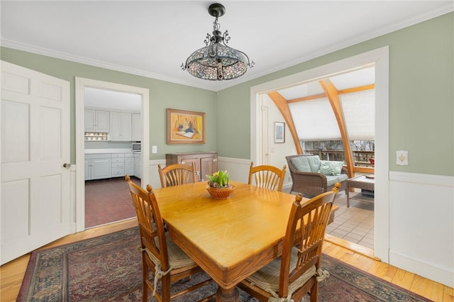 dining area featuring crown molding and wood finished floors