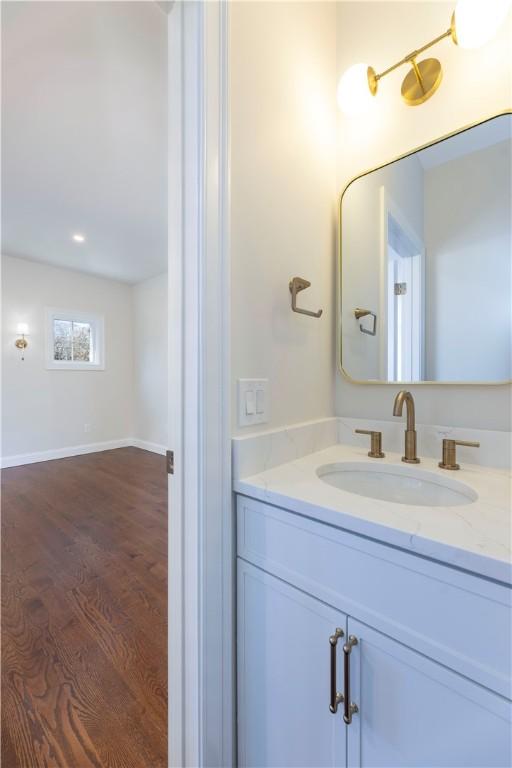 bathroom featuring vanity, baseboards, and wood finished floors