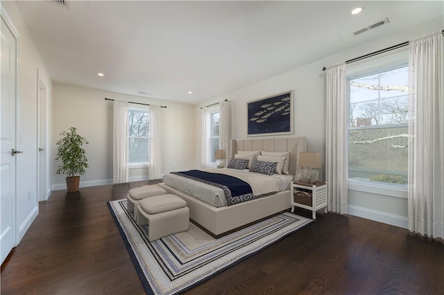 bedroom with dark wood-style floors, recessed lighting, visible vents, and baseboards