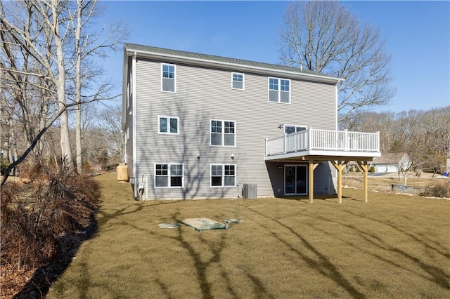 back of property with cooling unit, a lawn, and a wooden deck