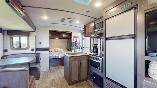 kitchen featuring light countertops, visible vents, appliances with stainless steel finishes, a sink, and light wood-type flooring