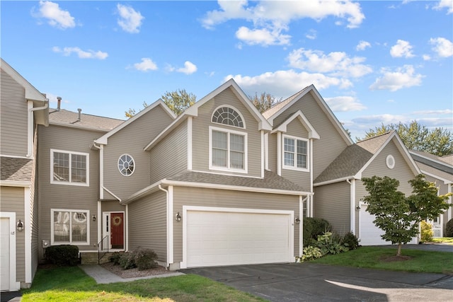 view of front of home featuring roof with shingles, driveway, and an attached garage