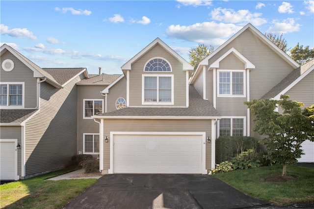 view of front of property with driveway, an attached garage, and a shingled roof