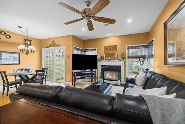 living room with light wood-type flooring, a premium fireplace, baseboards, and recessed lighting