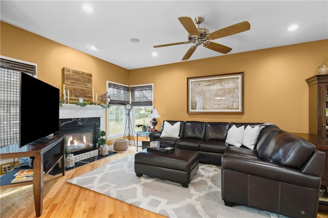 living area featuring ceiling fan, wood finished floors, a high end fireplace, and recessed lighting