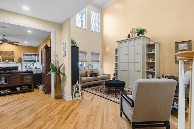 living room featuring recessed lighting, a high ceiling, ceiling fan, wood finished floors, and baseboards