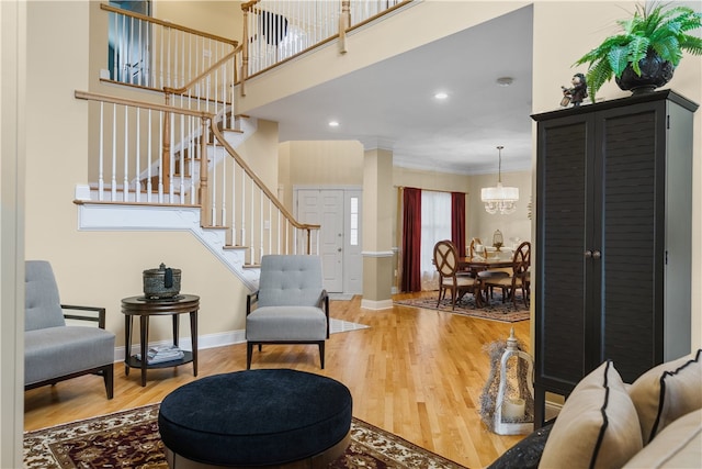 interior space featuring wood finished floors, baseboards, stairs, ornamental molding, and ornate columns