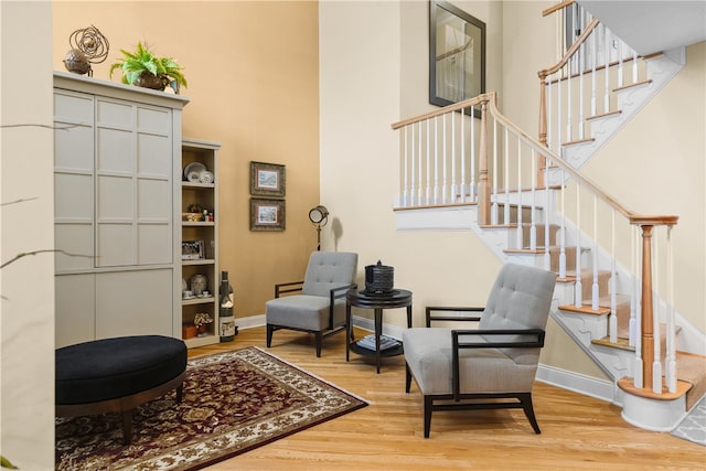 living area featuring stairway, wood finished floors, and baseboards