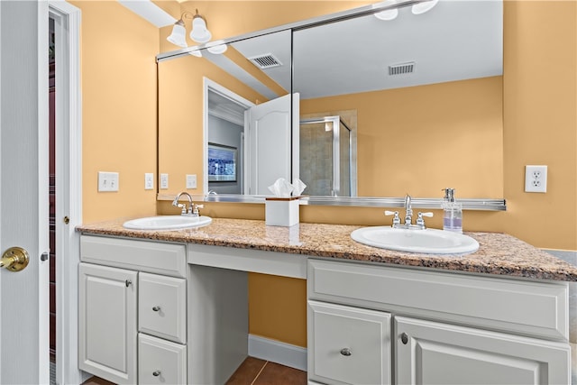 bathroom with visible vents, a sink, a shower stall, and double vanity