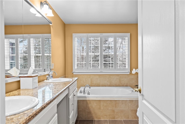 full bathroom featuring double vanity, a garden tub, tile patterned flooring, and a sink