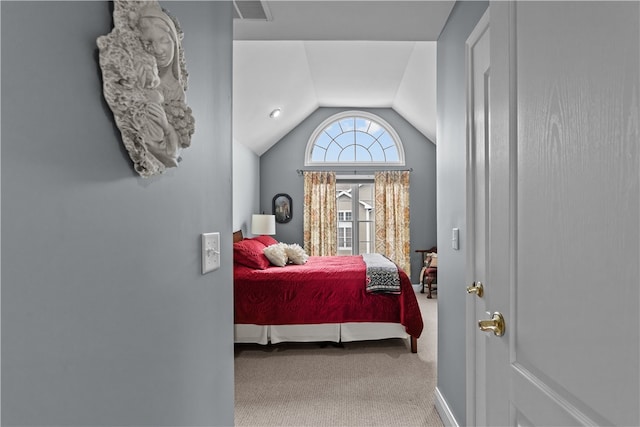 bedroom featuring carpet floors, lofted ceiling, and visible vents