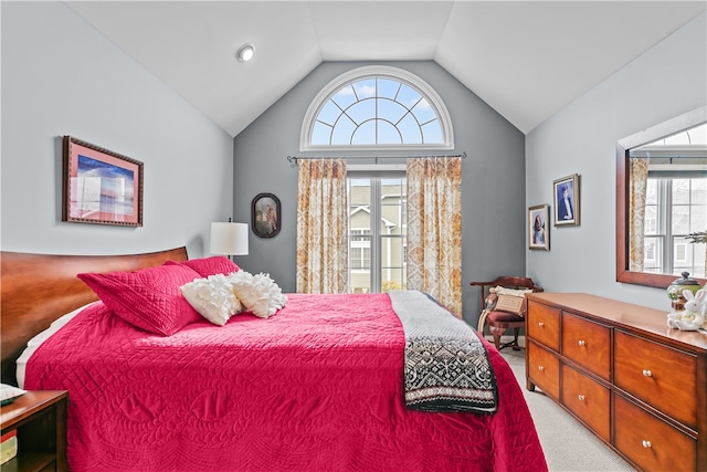 bedroom featuring light colored carpet, multiple windows, and vaulted ceiling