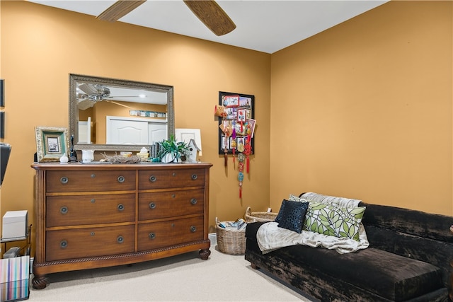 living area featuring carpet floors and ceiling fan