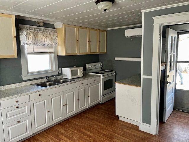 kitchen with white appliances, a wall unit AC, a sink, and dark wood-style flooring