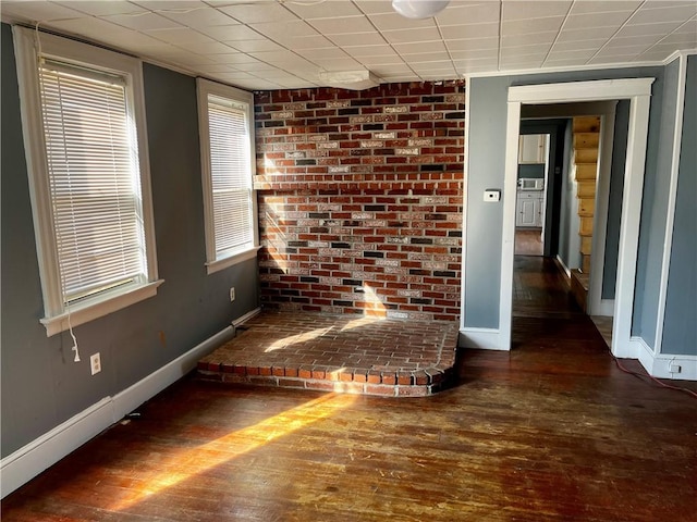 empty room with hardwood / wood-style flooring and baseboards