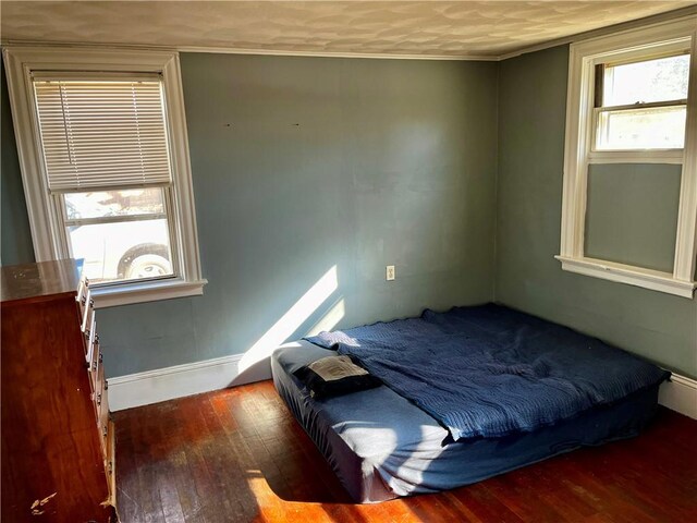 bedroom with baseboards and hardwood / wood-style flooring