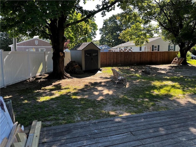 view of yard with an outbuilding, a fenced backyard, and a storage shed