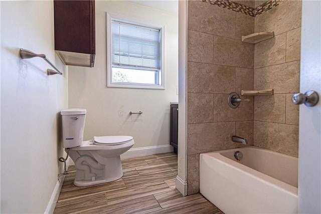 full bath with bathtub / shower combination, wood finished floors, toilet, and baseboards