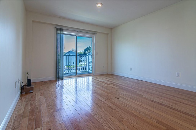 spare room with light wood finished floors and baseboards