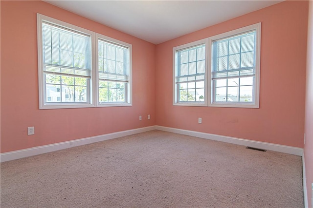 spare room with baseboards and visible vents