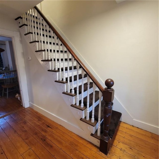 staircase featuring wood-type flooring and baseboards