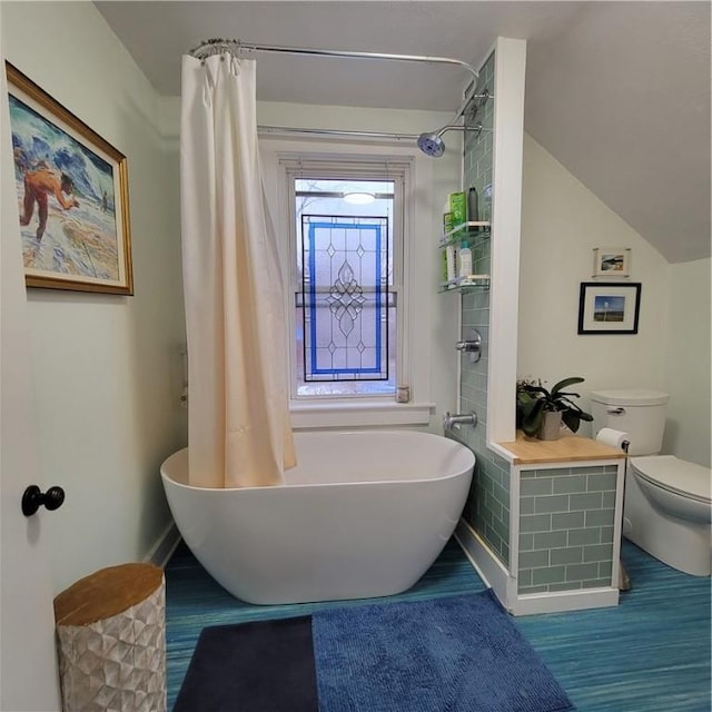 full bathroom with toilet, a freestanding tub, and curtained shower