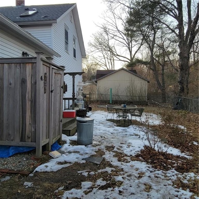 snowy yard featuring fence