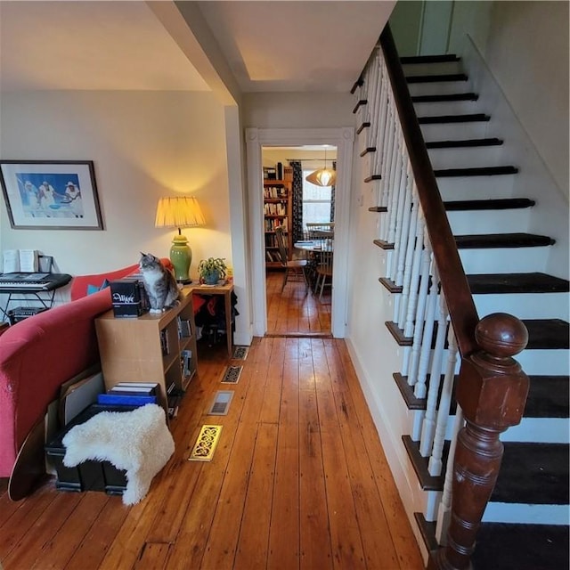 interior space featuring baseboards, hardwood / wood-style floors, and stairs