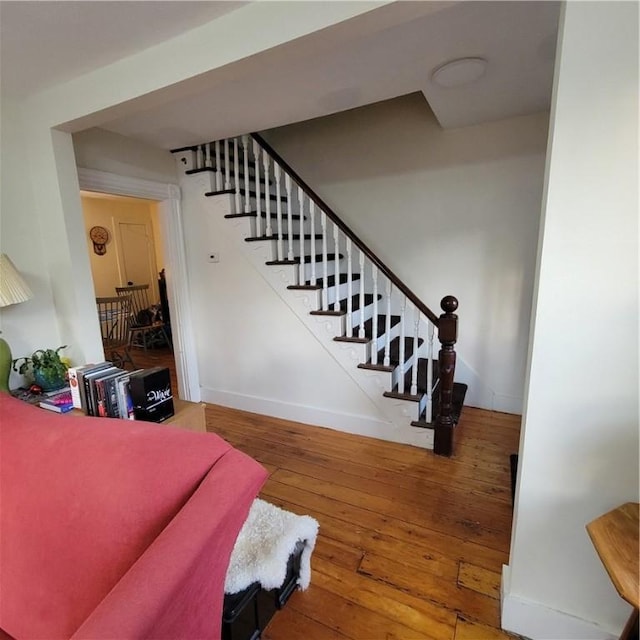 staircase featuring baseboards and hardwood / wood-style flooring