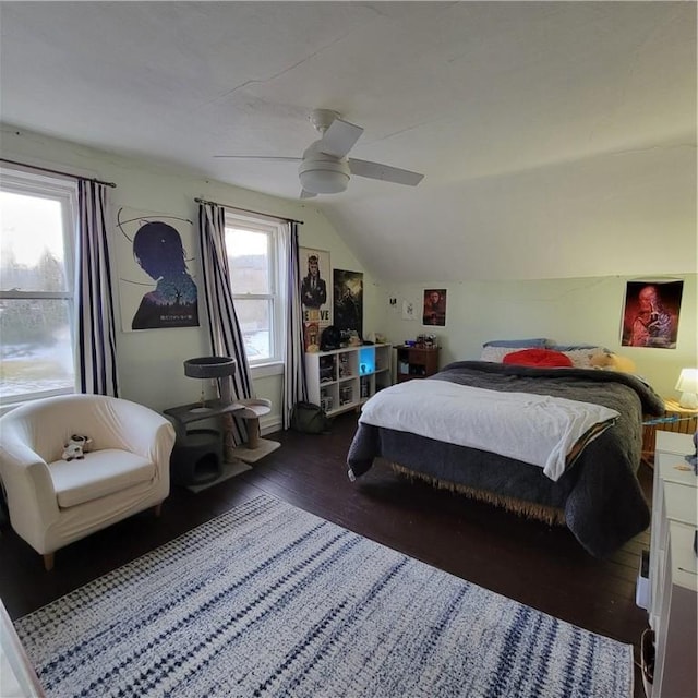 bedroom with a ceiling fan, vaulted ceiling, and hardwood / wood-style floors