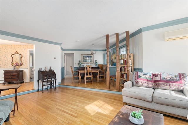 living room with a wall unit AC, wallpapered walls, ornamental molding, and wood finished floors