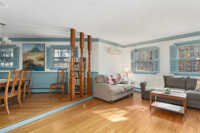 living area featuring baseboard heating, an inviting chandelier, ornamental molding, wood finished floors, and a wall mounted air conditioner