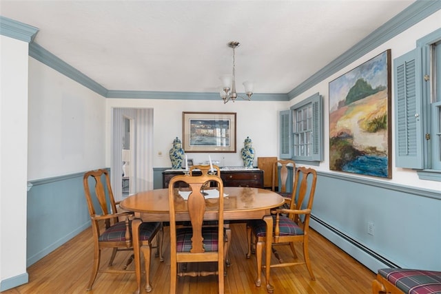 dining room with baseboards, baseboard heating, crown molding, light wood-type flooring, and a notable chandelier