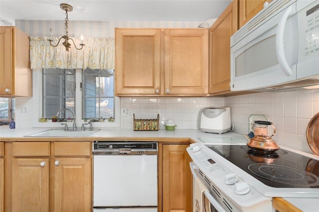 kitchen with light countertops, white appliances, a sink, and tasteful backsplash