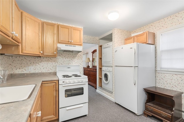 kitchen with wallpapered walls, under cabinet range hood, white appliances, and stacked washer and dryer