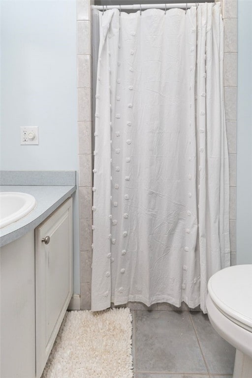 full bathroom with toilet, tile patterned flooring, and vanity