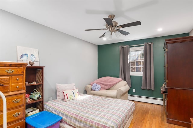 bedroom featuring ceiling fan, light wood finished floors, a baseboard radiator, and recessed lighting