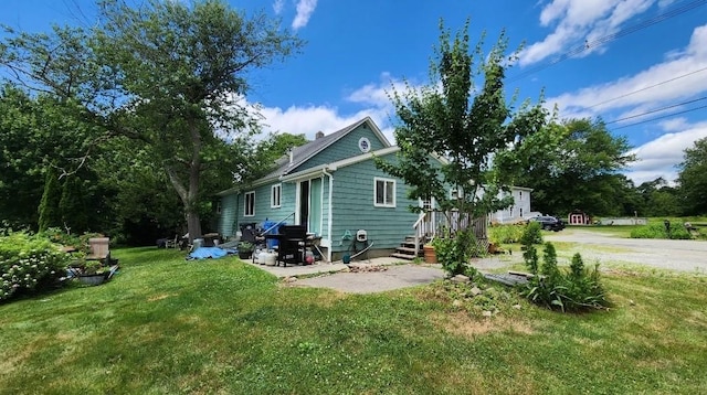 back of property with a lawn and a patio area