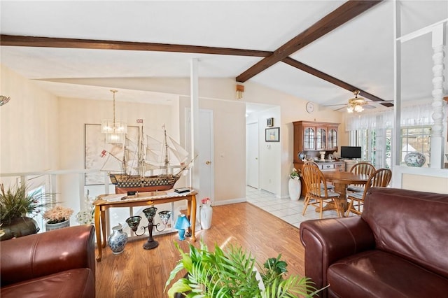 living area featuring lofted ceiling with beams, ceiling fan with notable chandelier, and wood finished floors