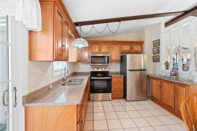 kitchen with brown cabinetry, light stone counters, vaulted ceiling with beams, stainless steel appliances, and a sink