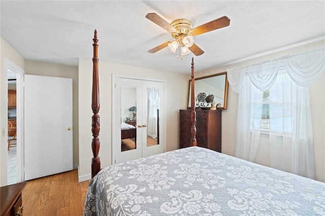 bedroom featuring ceiling fan, french doors, and wood finished floors