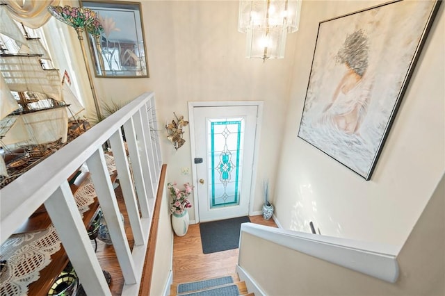 foyer with baseboards, a notable chandelier, stairway, and wood finished floors