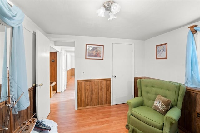 living area with light wood-style flooring and wainscoting