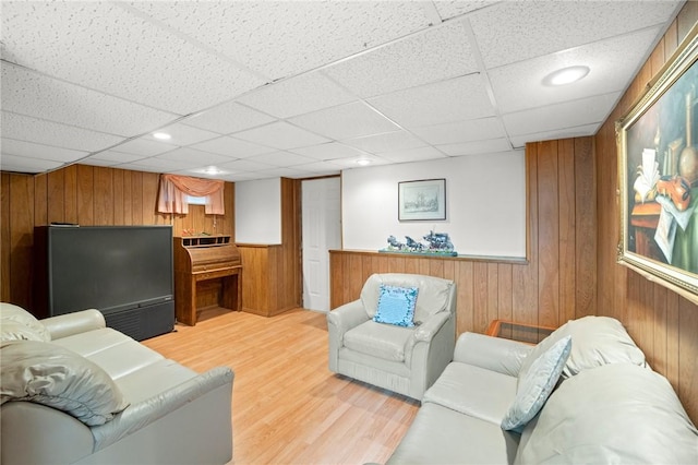 living room with a wainscoted wall, a paneled ceiling, recessed lighting, light wood-style floors, and wood walls