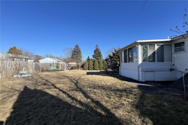 view of yard with a sunroom and fence