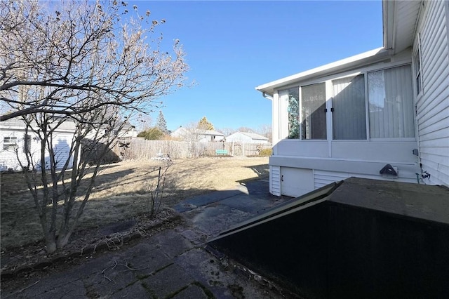 view of yard with fence and a sunroom