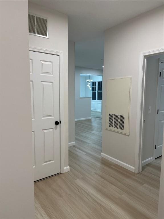 hallway featuring baseboards, visible vents, and light wood-style floors