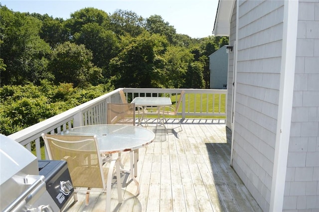 deck featuring outdoor dining space and a yard