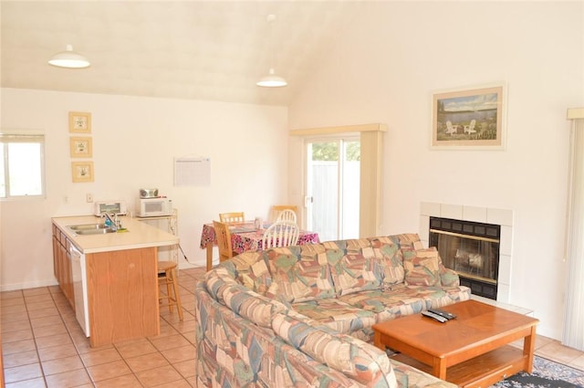 living area with lofted ceiling, a fireplace, and light tile patterned floors