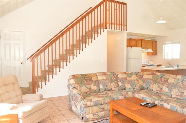 living area featuring stairs, high vaulted ceiling, and light tile patterned flooring